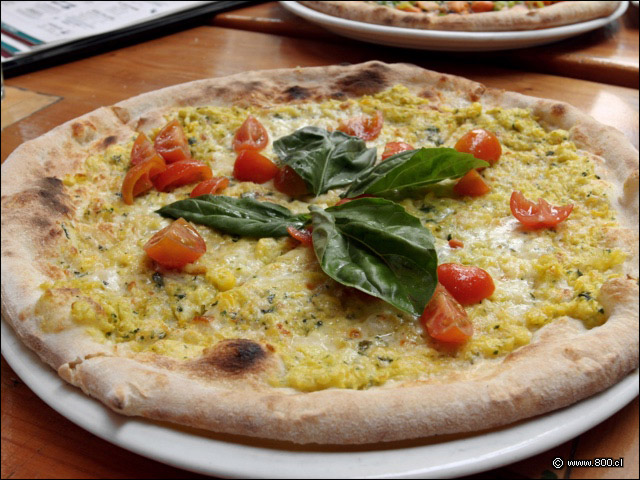 Pizza choclera, con pastelera de choclo, tomates cherry y albahaca